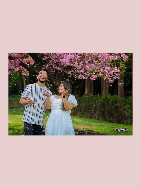 Couple portrait beneath pink blossoms